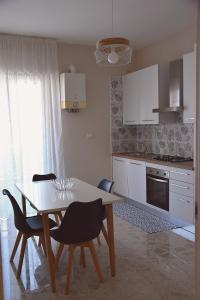 uma cozinha com mesa e cadeiras num quarto em Russo Apartment em Termoli