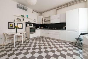 eine Küche mit weißen Schränken und einem karierten Boden in der Unterkunft Celestia Canal View renovated apartment in Venedig