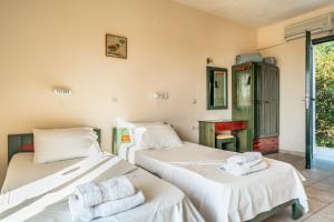 a room with two beds with towels on them at Anemona studio C in Katelios