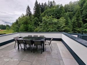 una mesa y sillas en un balcón con árboles en Ferienwohnung Yilmaz, en Bruck an der Großglocknerstraße