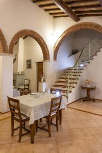 a dining room with a table and a staircase at Pieve mirabella - casa con vista panoramica in Città della Pieve