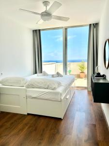 ein weißes Schlafzimmer mit einem Bett und einem Deckenventilator in der Unterkunft MyFlats Luxury VistaMar in Gran Alacant + 11 Fotos
