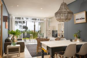 a dining room and living room with a table and chairs at Stylish Beachscape in Umdloti in Umdloti