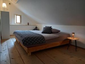 a bedroom with a bed and a table on a wooden floor at GIRBL bio APARTMENTS - Haus Girbl in Strobl