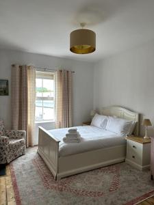 ein Schlafzimmer mit einem Bett, einem Stuhl und einem Fenster in der Unterkunft The Hideout - Top of the Town - Apartment in Stroud in Stroud