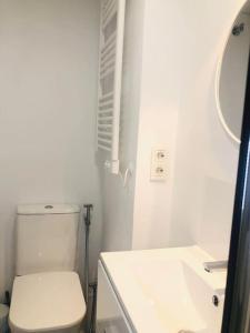 a white bathroom with a toilet and a sink at Espiral Abades in Córdoba