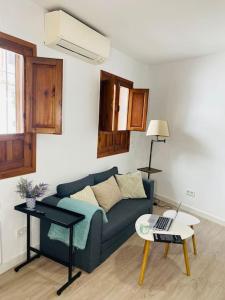 a living room with a blue couch and a table at Espiral Abades in Córdoba