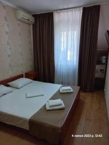 a bedroom with a bed with two towels on it at Hotel LaMa 2 in Kyiv