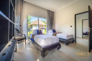 a bedroom with two beds and a tv and a mirror at Villa Akasa Segara Beachfront and Private Pool in Banjar +91 photos