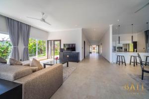 a large living room with a couch and a kitchen at Villa Akasa Segara Beachfront and Private Pool in Banjar