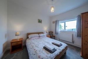 a bedroom with a bed with towels on it at Five Acres - Bwnthyn Ar Y Tir in Conwy