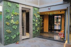 a lobby with a green wall with plants at Hotel Haris MG Road Gurugram in Gurgaon