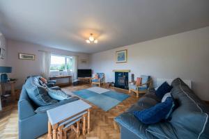 a living room with a blue couch and a table at Five Acres - Bwnthyn Ar Y Tir in Conwy