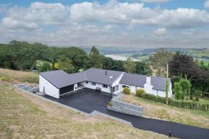 an aerial view of a white house with a garage at Five Acres - Bwnthyn Ar Y Tir in Conwy