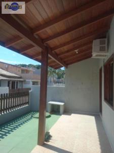 een patio met een houten pergola bij Casa 2 dormitórios e garagem. in Florianópolis