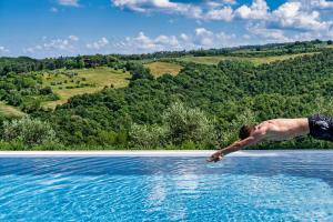 człowiek skaczący do basenu z wodą w obiekcie TORREVISTA - Opened 2022 w mieście Montaione