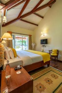 - une chambre avec un lit king-size et une table dans l'établissement amã Stays & Trails Raven's Nest , Kotagiri, à Kotagiri