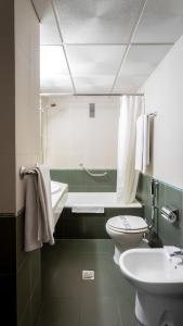 a bathroom with a sink and a toilet and a tub at Hotel Zeus in Merida