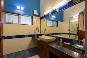 une salle de bain avec un lavabo et un miroir dans l'établissement amã Stays & Trails Raven's Nest , Kotagiri, à Kotagiri