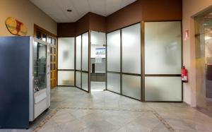 um corredor com portas de vidro num edifício em Hotel Zeus em Mérida