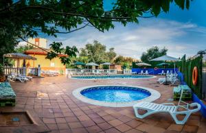 a pool at a resort with chairs and umbrellas at Hotel Zeus in Mérida