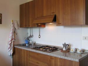 een keuken met houten kasten en een kookplaat met oven bij Appartamento Xibana in Bibione