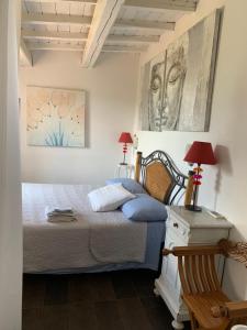 ein Schlafzimmer mit einem Bett und zwei Bildern an der Wand in der Unterkunft Il Cenacolo Di Sissi in Campagnano di Roma