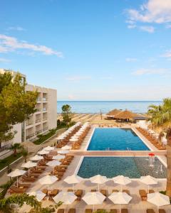 - une vue sur la piscine du complexe avec des chaises et des parasols dans l'établissement Sol Tropikal Durrës, à Durrës