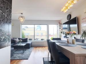 a living room with a table and a living room with a couch at Top floor city center flat with free parking in Oslo