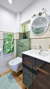 ein Badezimmer mit einem Waschbecken, einem WC und einem Spiegel in der Unterkunft Apartamenty Harnaś in Rytro