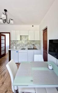 a kitchen with a blue table and white cabinets at Apartamenty Harnaś in Rytro
