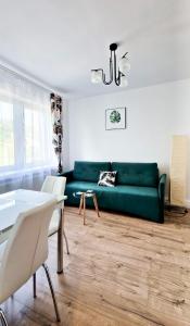 een woonkamer met een groene bank en een tafel bij Apartamenty Harnaś in Rytro