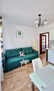 a living room with a green couch and a table at Apartamenty Harnaś in Rytro