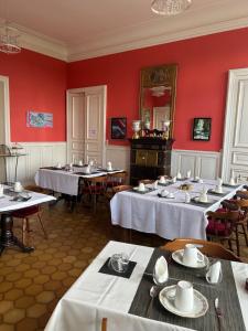un grupo de mesas en una habitación con paredes rojas en chambre romantique dans le château de la Bouchatte en Chazemais