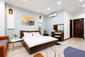 a hotel room with a bed and a television at The Lovenote Home in Ho Chi Minh City