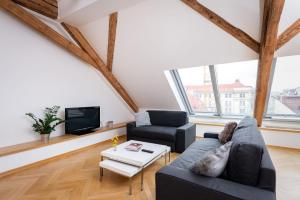 uma sala de estar com um sofá e uma televisão em Wishlist Old Prague Residences - New Town em Praga