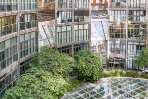 ein hohes Gebäude mit Bäumen davor in der Unterkunft Gasometer Apartment - Designer Building with Amazing View in Wien