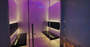 a bathroom with a glass shower with purple lighting at Hotel Tigullio Et De Milan in Santa Margherita Ligure +37 photos