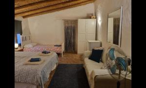 a bedroom with two beds and a couch and a mirror at Lemontree house set in the countryside. in Água de Tábuas