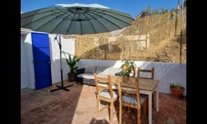 a patio with a table and an umbrella at Lemontree house set in the countryside. in Água de Tábuas