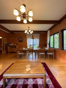 a dining room with a table and chairs and windows at FLYING HOUSE in Chikuni