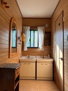 ein Badezimmer mit 2 Waschbecken und einem Spiegel in der Unterkunft FLYING HOUSE in Chikuni