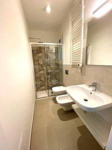 a bathroom with a toilet and a sink and a shower at IL GIARDINO DAMARE in Donnalucata