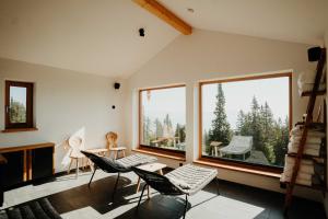 Zimmer mit Stühlen und großen Fenstern mit Aussicht in der Unterkunft Knappenhütte in Villach