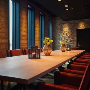 une salle de conférence avec une grande table et des chaises en bois dans l'établissement Riddergaarden, à Beitostøl