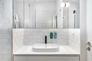 Baño blanco con lavabo y espejo en Canto De Luz - Luxury Maison, en Oporto