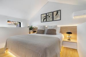 a white bedroom with a large bed with two pillows at Canto De Luz - Luxury Maison in Porto