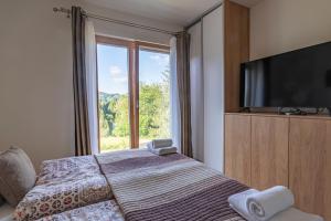 a bedroom with a bed and a large window at Apartmán Jesienka, Hillside in Dolný Kubín