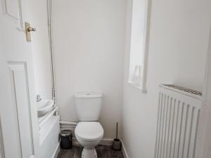 a white bathroom with a toilet and a sink at Bentley House - By Sigma Stays in Crewe