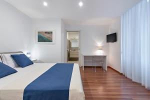 a bedroom with a blue and white bed and a television at Suite San Biagio in Lecce